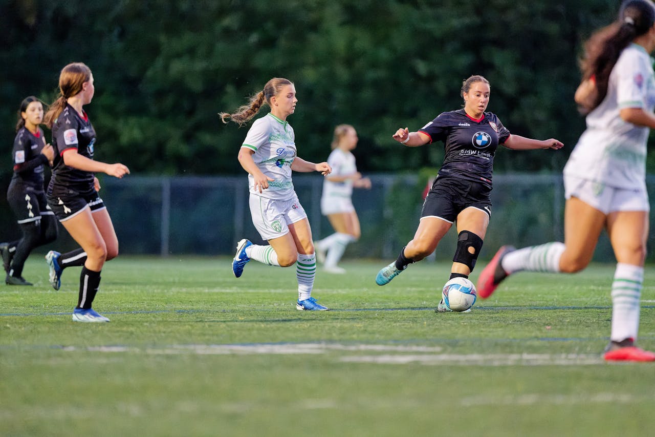 Services Dynamic scene from a women's soccer match, capturing players in motion on the field.